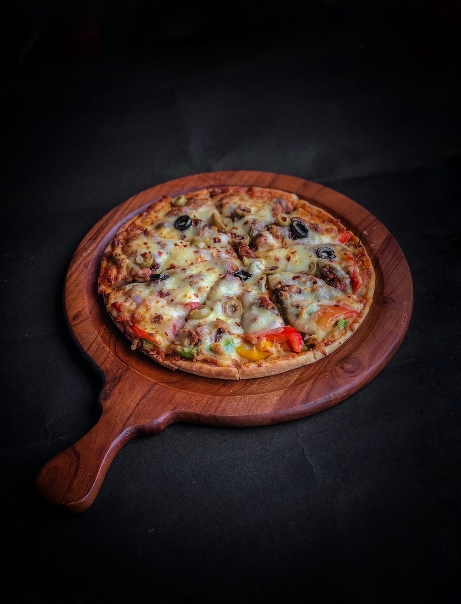 pizza on brown wooden round tray